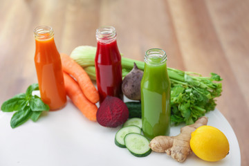 Bottles with various fresh vegetable juices on table