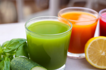 Glasses with various fresh juices on table, close up