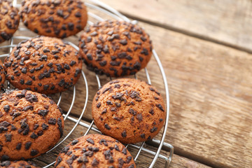 Cooling rack with delicious oatmeal cookies on table, closeup