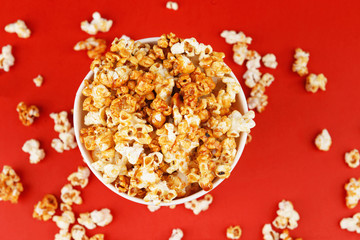 Fototapeta na wymiar Cup with caramel popcorn on color background