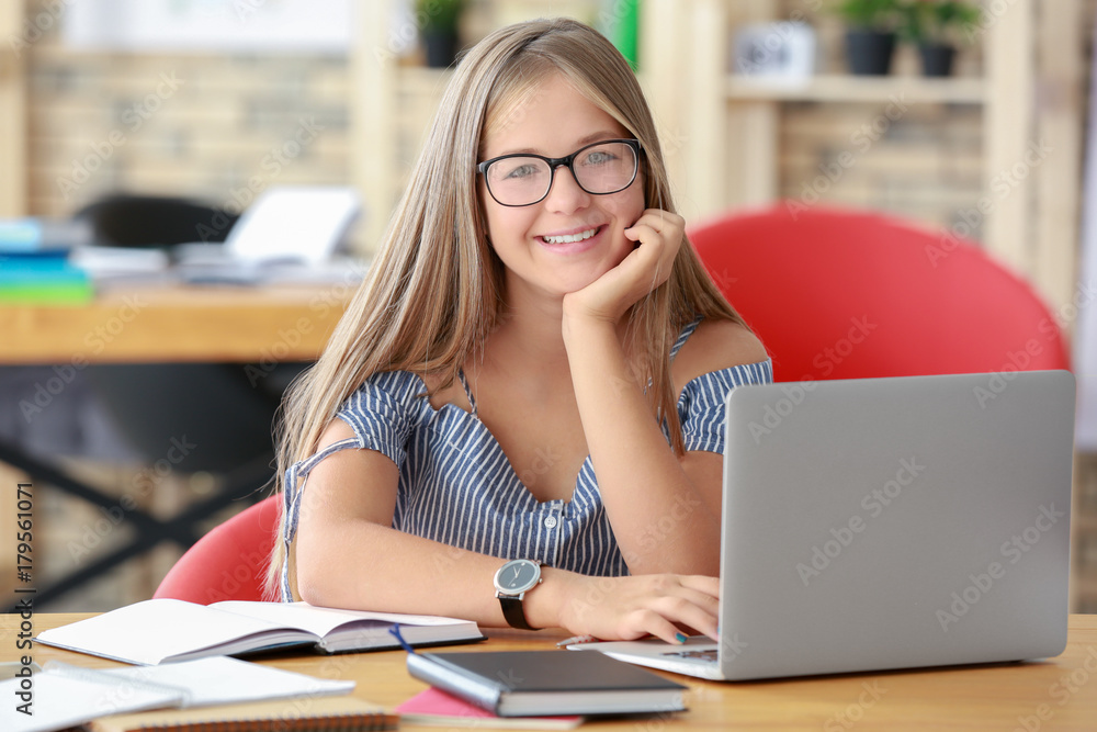 Wall mural student with laptop studying indoors