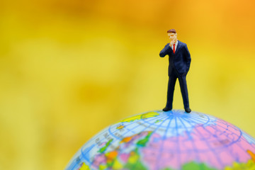 Global and Business Concept. Businessman miniature people figure standing on mini world ball model.