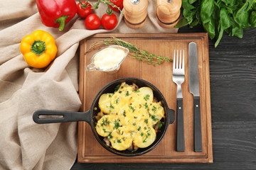 Composition with delicious potato casserole in frying pan on table
