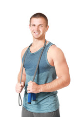 Young man with jumping rope on white background