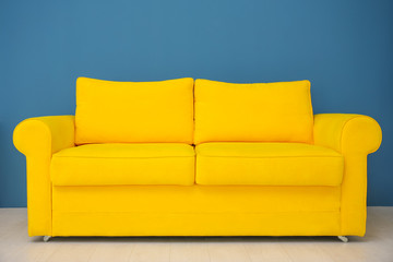 Bright yellow sofa against color wall indoors