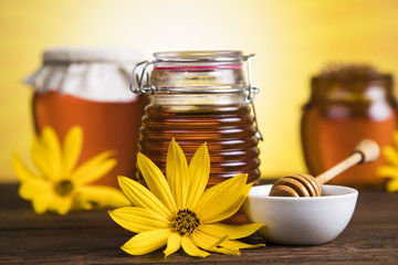 Honey and wooden stick are on a table