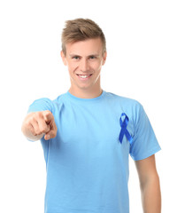 Fototapeta premium Young man wearing t-shirt with blue ribbon on white background. Prostate cancer awareness concept