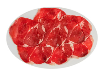 raw beef fillets on a plate .