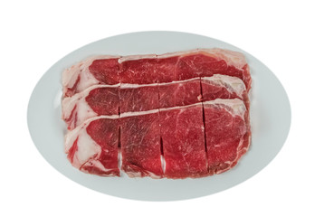 raw beef fillets on a plate .