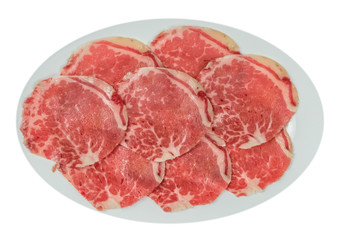 raw beef fillets on a plate .