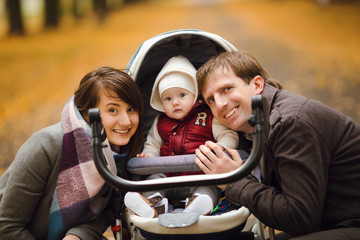 baby in a stroller with parents on an autumn walk