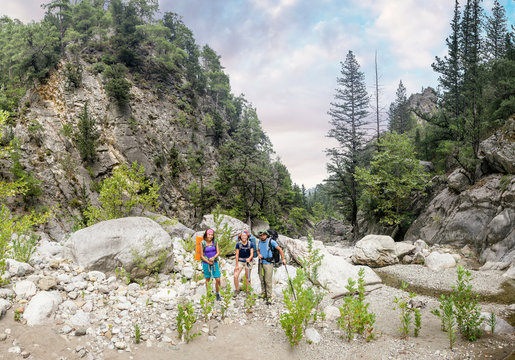 Group of friends hikers and travelers walking at Goynuk Canyon in Turkey, passing the stream, Lycian way concept