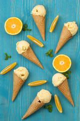 Fototapeta na wymiar Orange ice cream cones texture flat lay
