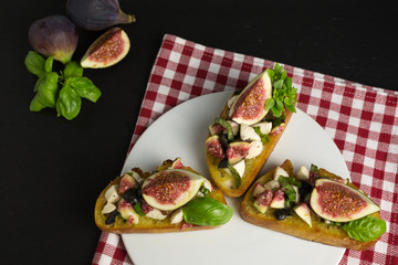 bruschetta of fresh ciabatta bread with mozzarella, black olives, figs and basil