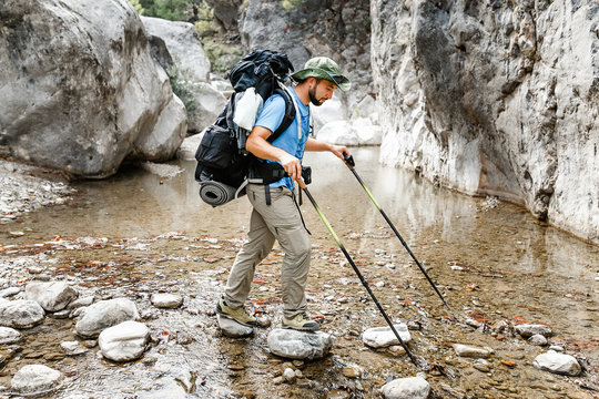 Backpacker man wading small mountain river in Goynuk canyon, lycian way, Turkey