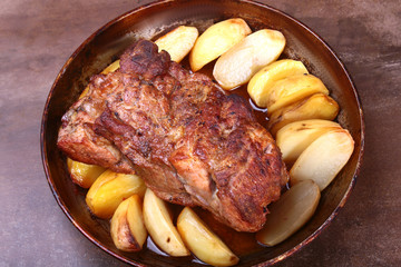 Juicy pork neck chops are grilled with potatoes on a stone Background.