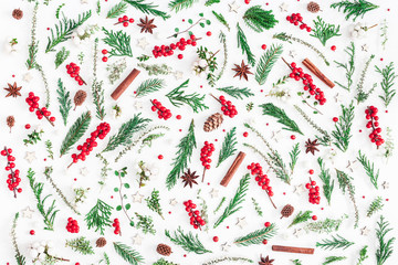 Christmas composition. Pattern made of christmas tree branches, red berries, cinnamon sticks, anise...