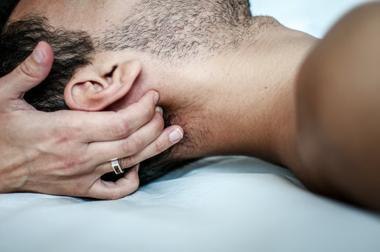 fisioterapista massaggia giovane paziente per curare un dolore cervicale
