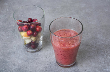 Fruit smoothies with blueberries, raspberries, apple, orange , pear and banana on  gray background