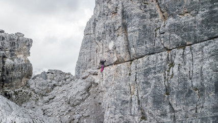 Female rock climber on the Cinque Torri highest Peak. Cortina D'Ampezzo, Dolomites, Italy.