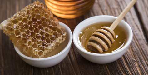 Sweet honey in the comb, glass jar on wooden background