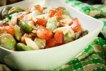 Broad bean salad with tomatoes, onion and olive