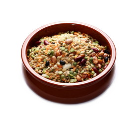 Mixed dried legumes and cereals in clay bowl isolated on white background