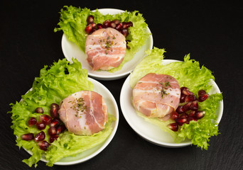 goat cheese with bacon on a frisee lettuce leaf with pomegranate as garnishing