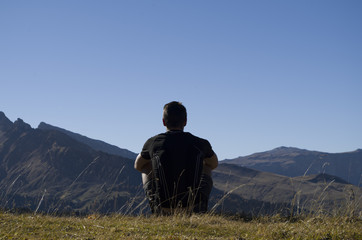 Boy thinking on the top of a mountain