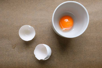 Obraz na płótnie Canvas Eigelb in Tasse und weiße Eierschalen