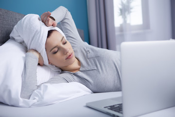 young woman lying in the bed with notebook