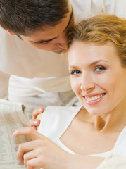 Obraz premium Happy couple reading newspaper together