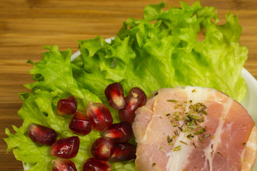 goat cheese with bacon on a frisee lettuce leaf with pomegranate as garnishing