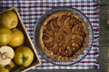 Homemade apple quince pie with fresh fruits on rustic wooden background. Top view