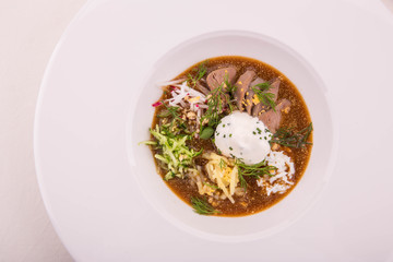 Okroshka with tongue of a lamb on grain kvass with horse-radish and mustard, is served with sour cream and fennel