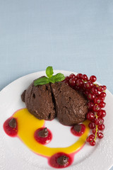 chocolate mousse on plate with pureed fruit in red and yellow