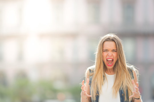 Angry and screaming young girl, portrait photo with copy space