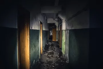 Zelfklevend Fotobehang Walkway in creepy abandoned building, dark scary corridor with many doors, horror background concept © DedMityay