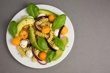 pasta salad consisting of fusili with mozzarella and melon with avocado and red onions