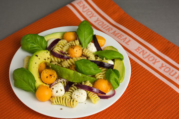 pasta salad consisting of fusili with mozzarella and melon with avocado and red onions