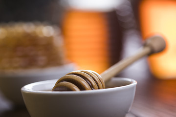Honey and wooden stick are on a table
