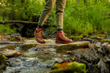 Female hiker crossing a small mountain stream