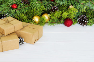 Fir branches with ornaments - gift box, pine cones holly and baubles. Christmas background, copy space