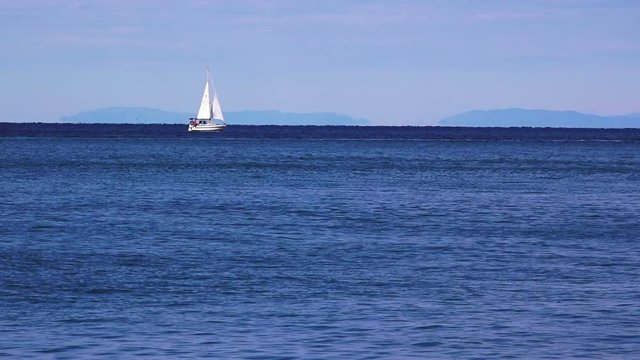 Sailing at the sea, yacht on the horizon over water