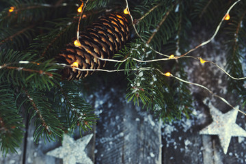 Christmas background. Christmas tree, pine cones and snow over wooden board. Design mockup