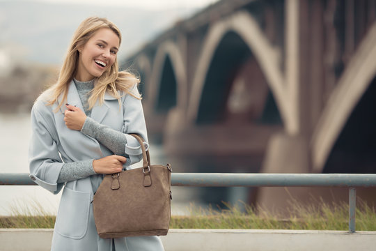 Young Woman In Blue Coat. Autumn City Background.