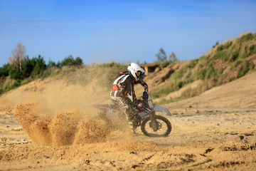 Enduro, motocyklista na motorze crossowym na piachu.
