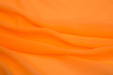 Obraz premium bright orange fabric lined with soft folds, artificial silk