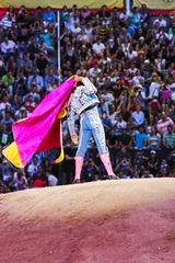 Selbstklebende Fototapete Stierkampf Stierkämpfer macht Bewegungen vor den Zuschauern in der Arena