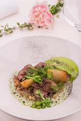 The beef tongue fried on a grill, is served with fried potatoes, cream from horse-radish with greens